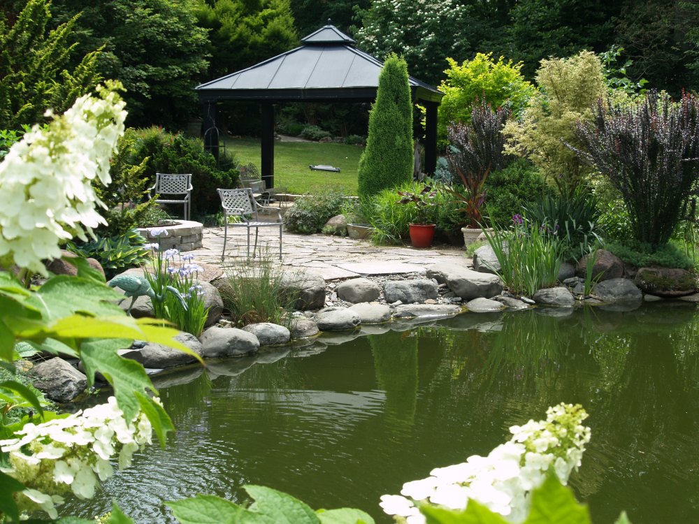 Looking across the koi pond to the stone patio and pavilion